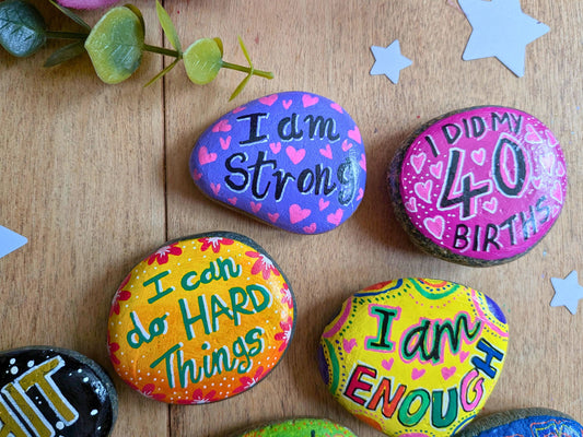 Painted pebble badges reading I am strong, I can do hard things, I am enough and 40